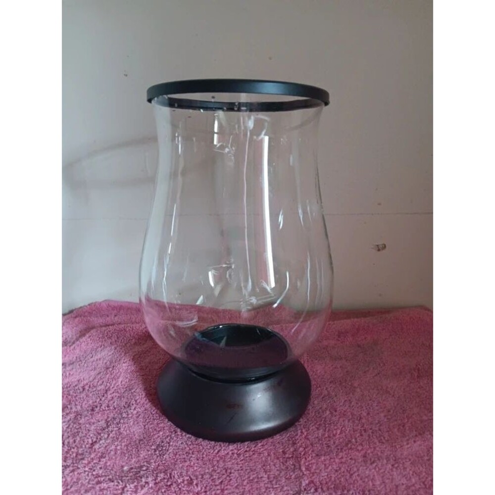 Clear teardrop/hourglass shaped glass chimney paired with a round platform base.